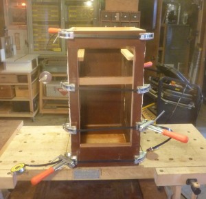 Pedestal glue-up showing the fenestration for the door below, and for the drawer, the rails for which can be seen uppermost.